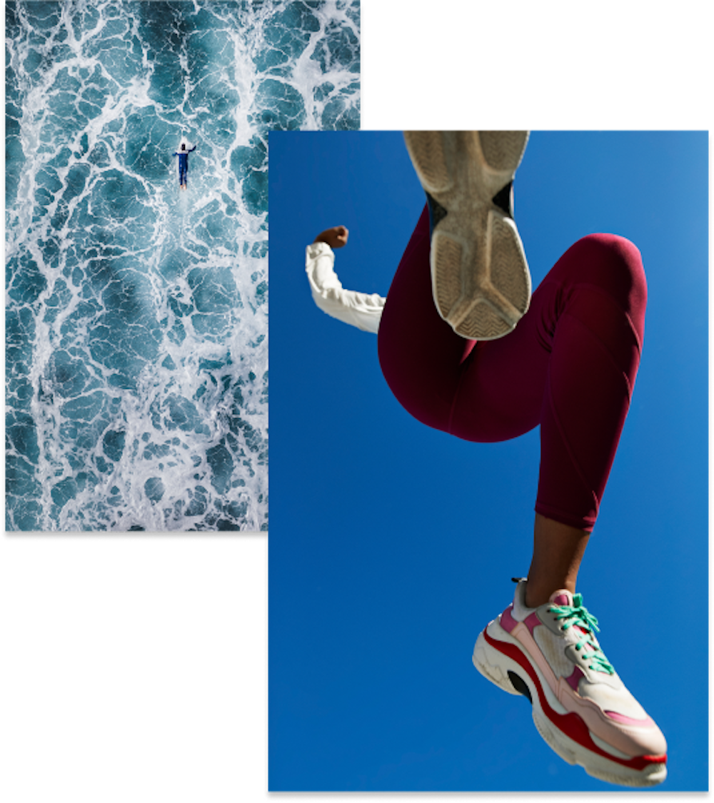 Person jumping against a blue sky, an open body of water as someone dives in 